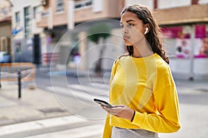 Young african american woman listening to music at street