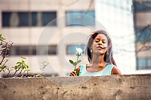 Young African American Woman missing you with white rose in New