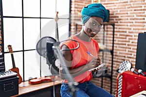 Young african american woman musician composing song at music