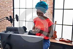 Young african american woman musician composing song at music