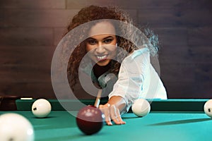 Young African-American woman playing Russian billiard