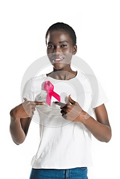 young african american woman pointing at pink ribbon and smiling at camera