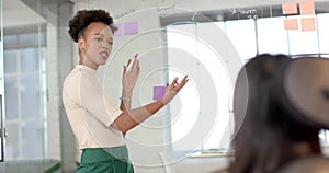 Young African American woman presents in a bright business office