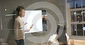 Young African American woman presents in a modern office setting