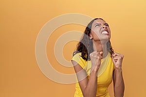 Young african american woman screaming over isolated yellow background