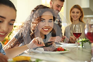 Young African-American woman serving food in kitchen. Cooking class