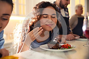 Young African-American woman serving food in kitchen. Cooking class