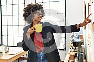 Young african american woman smiling confident drinking coffee at office