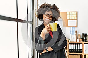 Young african american woman smiling confident drinking coffee at office