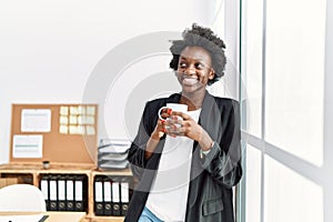 Young african american woman smiling confident drinking coffee at office