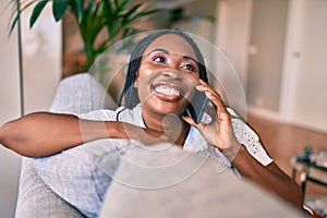 Young african american woman smiling happy sitting using smartphone at home