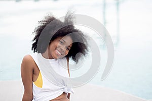 Young African American woman smiling in the poolside, female relax and leisure.