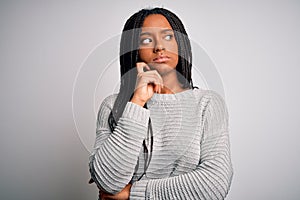 Young african american woman standing casual and cool over grey  background with hand on chin thinking about question,