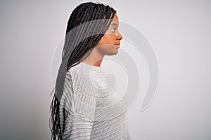 Young african american woman standing casual and cool over grey isolated background looking to side, relax profile pose with