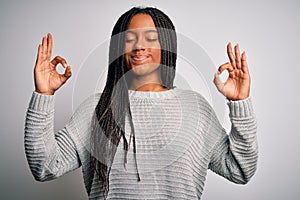 Young african american woman standing casual and cool over grey isolated background relax and smiling with eyes closed doing