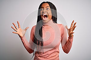 Young african american woman standing casual and cool over white isolated background crazy and mad shouting and yelling with