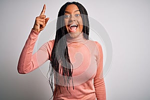 Young african american woman standing casual and cool over white isolated background pointing finger up with successful idea