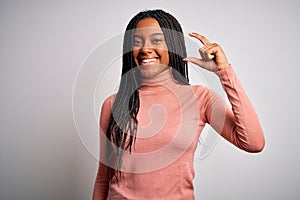 Young african american woman standing casual and cool over white isolated background smiling and confident gesturing with hand