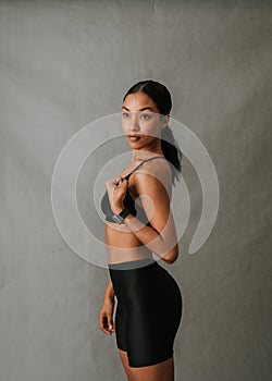 Young African American woman standing with flexed arm and working out