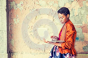 Young African American Woman studying, working on laptop computer outside in New York