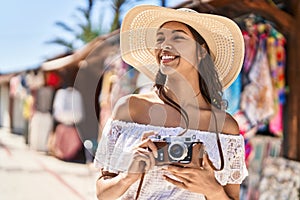 Young african american woman tourist smiling confident using camera at street