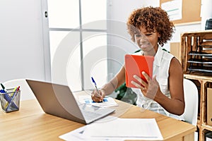 Young african american woman using touchpad working at office