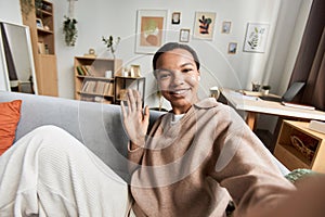 Young African American woman waving Hello to camera video chat or livestream