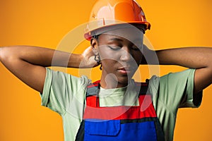 Young african american woman wearing architect hardhat against yellow background