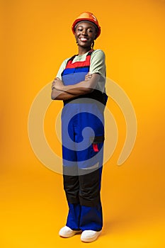 Young african american woman wearing architect hardhat against yellow background