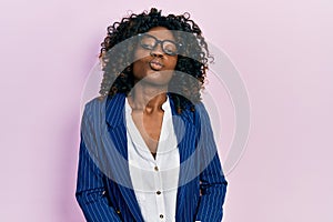Young african american woman wearing business clothes and glasses looking at the camera blowing a kiss on air being lovely and