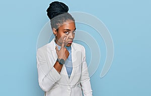 Young african american woman wearing business clothes pointing to the eye watching you gesture, suspicious expression