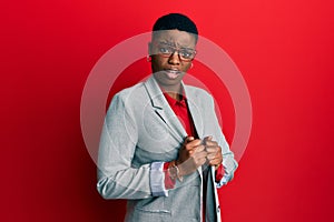 Young african american woman wearing business jacket and glasses clueless and confused expression