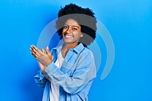 Young african american woman wearing casual clothes clapping and applauding happy and joyful, smiling proud hands together