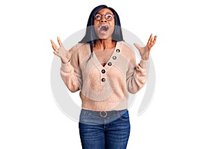 Young african american woman wearing casual clothes crazy and mad shouting and yelling with aggressive expression and arms raised