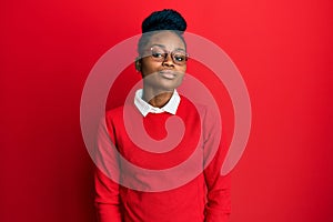 Young african american woman wearing casual clothes and glasses relaxed with serious expression on face