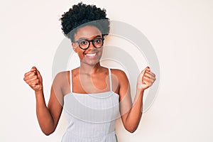 Young african american woman wearing casual clothes and glasses screaming proud, celebrating victory and success very excited with