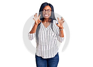 Young african american woman wearing casual clothes and glasses smiling funny doing claw gesture as cat, aggressive and sexy