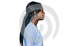 Young african american woman wearing casual clothes looking to side, relax profile pose with natural face with confident smile