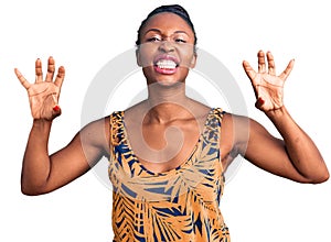 Young african american woman wearing casual clothes smiling funny doing claw gesture as cat, aggressive and sexy expression
