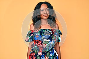 Young african american woman wearing casual clothes smiling looking to the side and staring away thinking