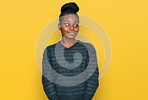 Young african american woman wearing casual clothes smiling looking to the side and staring away thinking