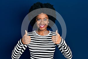 Young african american woman wearing casual clothes success sign doing positive gesture with hand, thumbs up smiling and happy