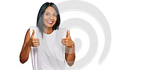 Young african american woman wearing casual clothes success sign doing positive gesture with hand, thumbs up smiling and happy