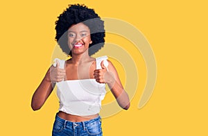 Young african american woman wearing casual clothes success sign doing positive gesture with hand, thumbs up smiling and happy