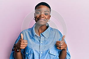 Young african american woman wearing casual clothes success sign doing positive gesture with hand, thumbs up smiling and happy