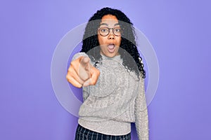 Young african american woman wearing casual sweater and glasses over purple background pointing displeased and frustrated to the