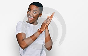 Young african american woman wearing casual white t shirt clapping and applauding happy and joyful, smiling proud hands together