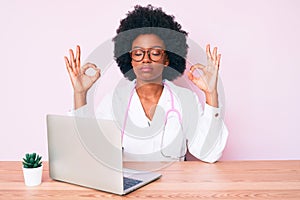 Young african american woman wearing doctor stethoscope working using computer laptop relax and smiling with eyes closed doing