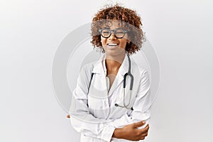 Young african american woman wearing doctor uniform and stethoscope happy face smiling with crossed arms looking at the camera