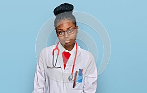 Young african american woman wearing doctor uniform and stethoscope looking sleepy and tired, exhausted for fatigue and hangover,